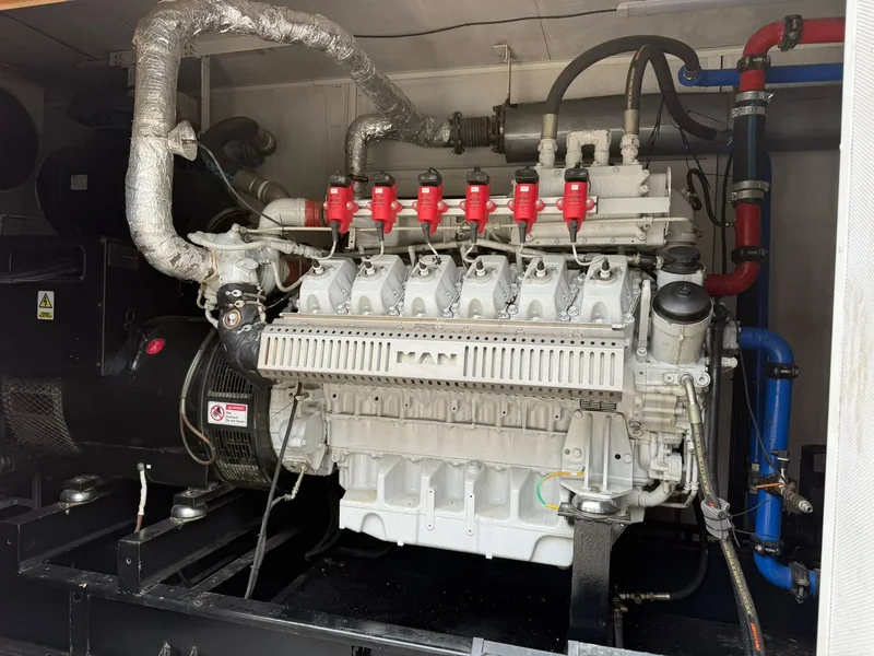 Motor a gas dentro de contenedor con válvulas de gas, escape aislado y tuberías de refrigeración