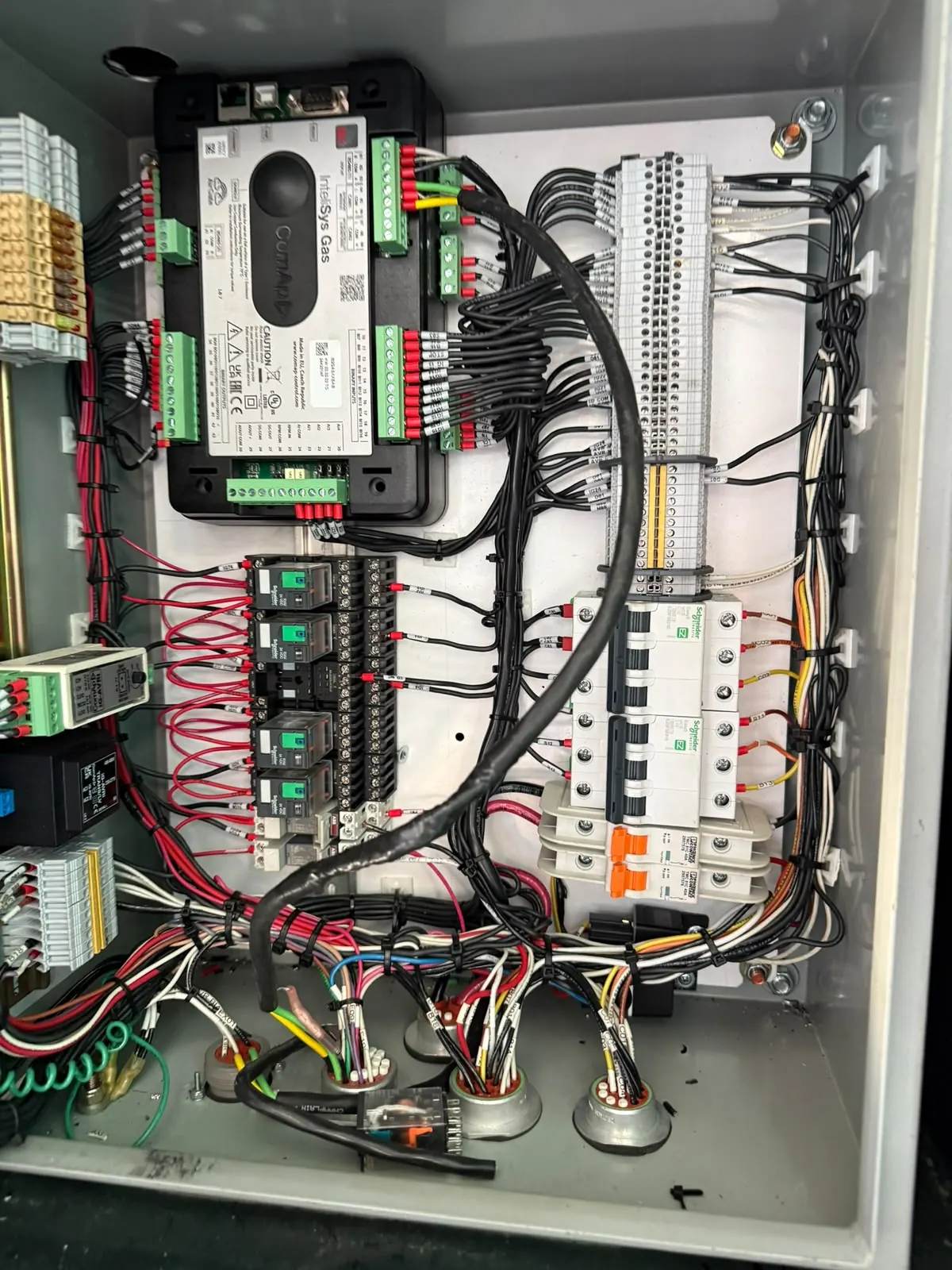 Interior del tablero de sincronismo con controlador de sincronismo, borneras y protecciones cableadas en taller propio