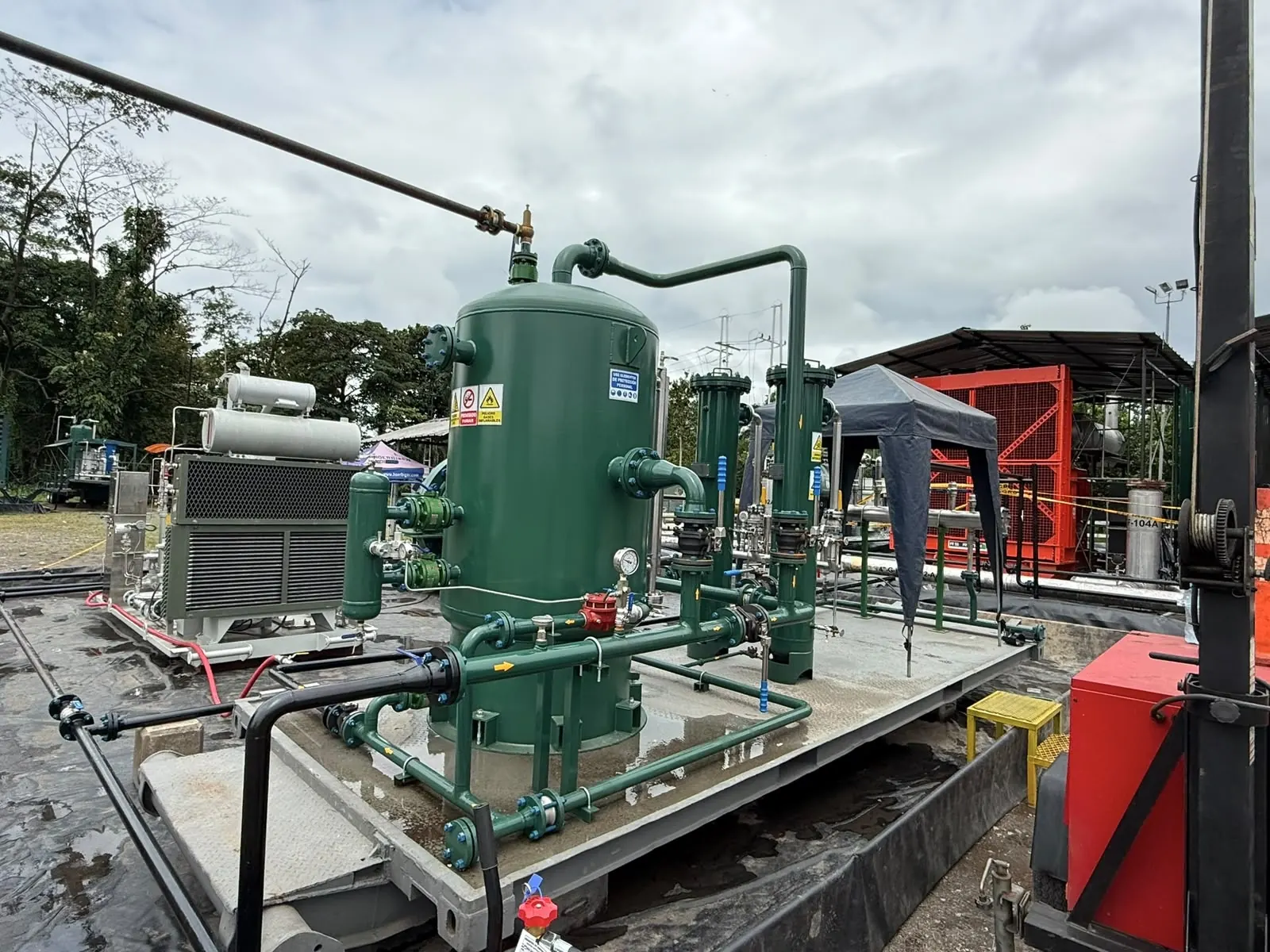 Estación de filtración de gas con separador vertical verde, filtros coalescentes e intercambiador montados sobre skid en campo